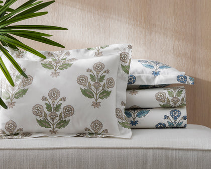 Green and blue Dalila floral print bedding stacked on a bench.