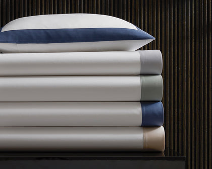 White Emory bedding stacked with a navy tailored border.