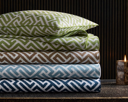 Gabriel fretwork print bedding stacked in green, brown, blue, and navy.