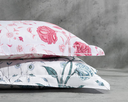 Khilana floral print pillows in pink and blue, stacked.