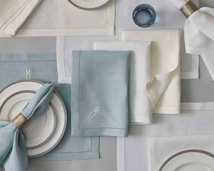 Valentina Hemstitch placemats and napkins in blue, cream, and white arranged with Greek key china.