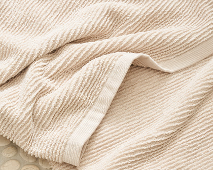 Tan ribbed Aman towel draped.