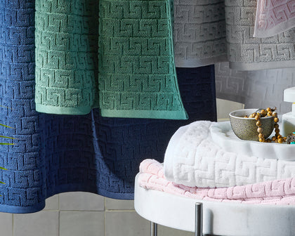 Athena greek-key textured towels in navy, green, gray, and pink, shown in detail.