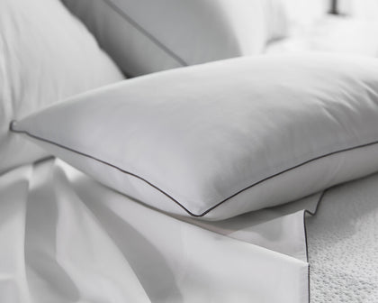 White Bryant pillow with charcoal piped edge.