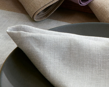 Gray Chamant linen napkin and placemat set on a dark plate.