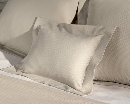 Tan Elliot textured pique pillows styled on a bed.