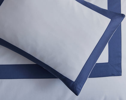 White pillow sham with a navy tailored border.