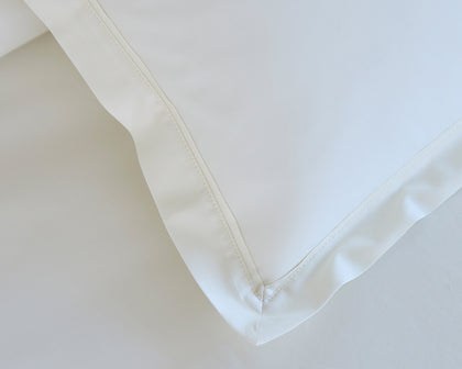 Ivory Gatsby pillow sham showing the hemstitched corner seam.