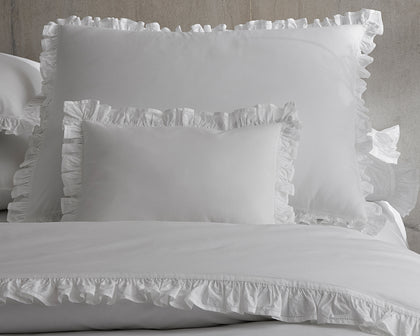 White Georgia ruffled pillows and duvet arranged on a bed.