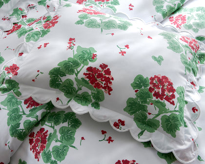 White Geranium print pillow with a scalloped edge in red and green floral pattern.