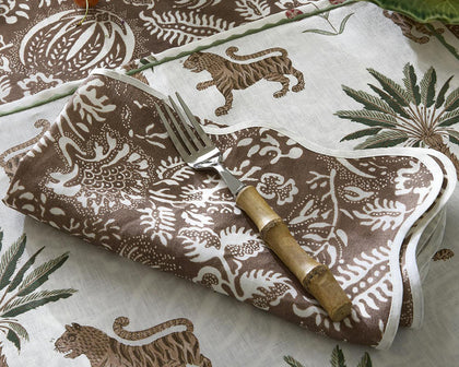 Tiger Palm print napkin with tigers and palm trees, folded with a fork on a matching tablecloth.