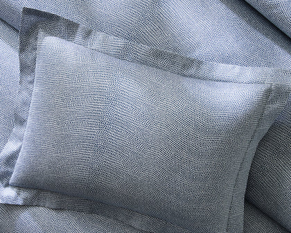 Blue-gray Jasper pebbled print sheets and a sham, styled on a bed.