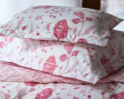 Pink Khilana floral print quilted pillows and bedding, styled on a bed.