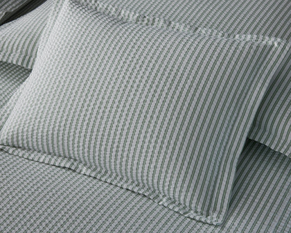 Green-striped Matteo bedding styled on a bed.