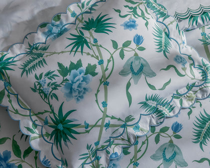 White Palmyra floral-print pillow sham with blue and green vines and a scalloped edge.