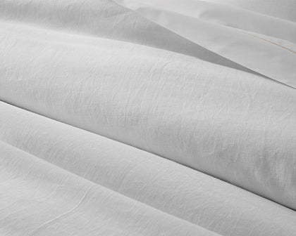 White linen Roman Hemstitch sheets draped in loose folds.