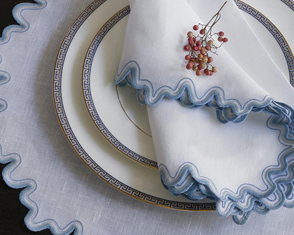 White Wave placemat and napkin with blue wavy trim on Greek key china.