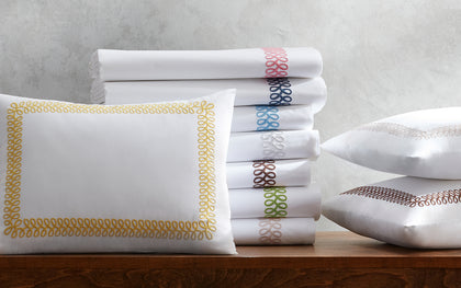 Astor Braid bedding with colorful looped embroidery on white sheets and shams