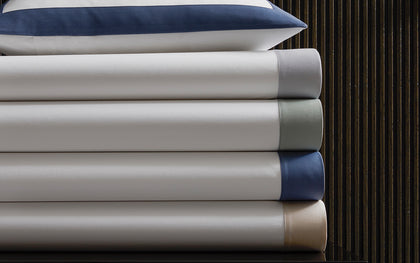 White Emory bedding stacked with a navy tailored border.