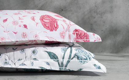 Khilana floral print pillows in pink and blue, stacked.