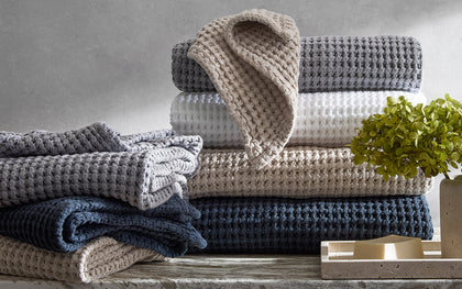 Nico waffle-weave towels stacked in charcoal, white, tan, and navy