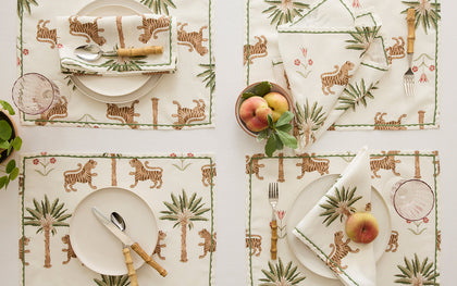 Tiger Palm placemats and napkins with tiger and palm tree print set for four with fresh peaches.