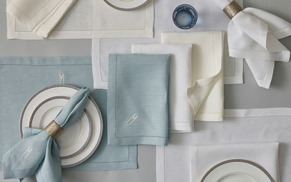 Valentina Hemstitch placemats and napkins in blue, cream, and white arranged with Greek key china.
