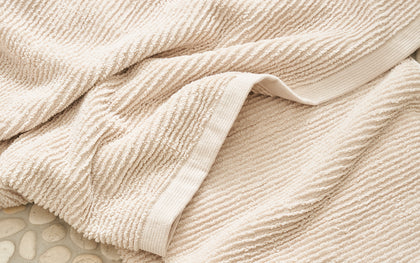 Tan ribbed Aman towel draped.