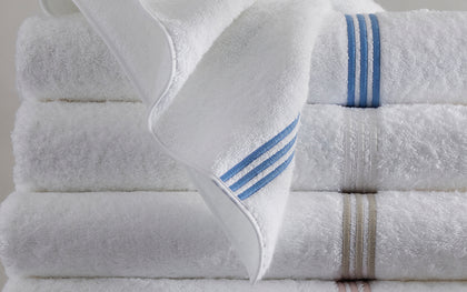 White Bel Tempo towels folded together with blue, tan, and pink stripe trim