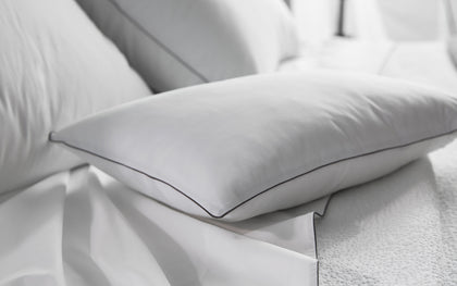 White Bryant pillow with charcoal piped edge.