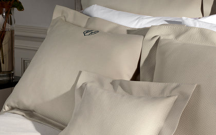 Tan Elliot textured pique pillows styled on a bed.