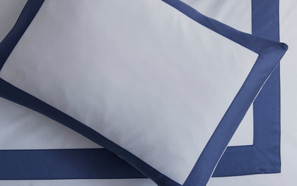 White pillow sham with a navy tailored border.
