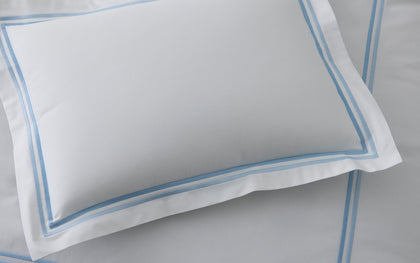 White Essex pillow sham with a double blue stitched border.