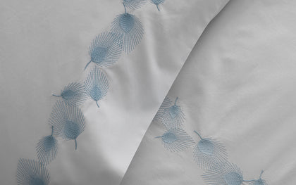 White pillow sham embroidered with a blue feather motif.