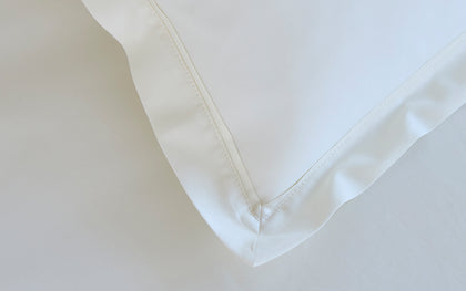 Ivory Gatsby pillow sham showing the hemstitched corner seam.