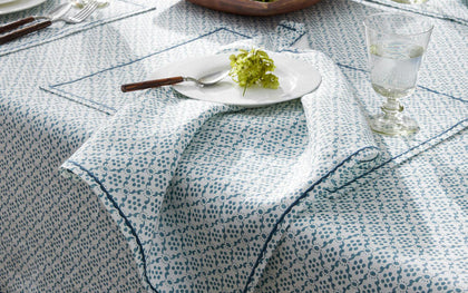 Blue Laksha medallion print tablecloth set with a white plate and green hydrangea.