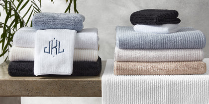 Francisco ribbed towels stacked in an array of colors on a bathroom shelf.