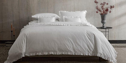 White Georgia ruffled bedding, styled on a bed.