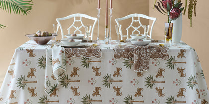 White Tiger Palm tablecloth with tiger and palm print set for two with candles and rattan chairs.